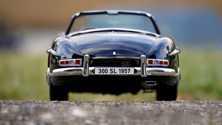Rear view of a vintage 1957 Mercedes 300 SL convertible, highlighting its emblem and classic design.
